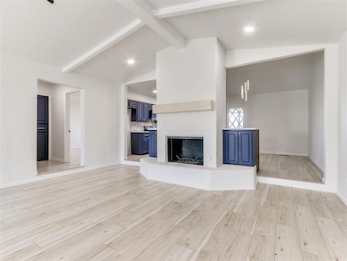 Unfurnished living room with beam ceiling, baseboa