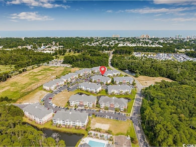 Aerial view of property's location with a large body of water and a tree filled landscape
