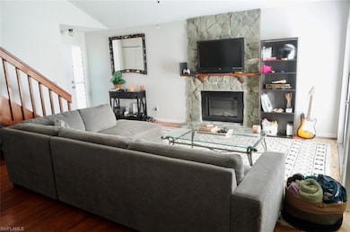 Living area with a fireplace, baseboards, wood fin