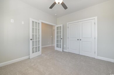 Unfurnished bedroom with light carpet, french doors, a closet, and ceiling fan