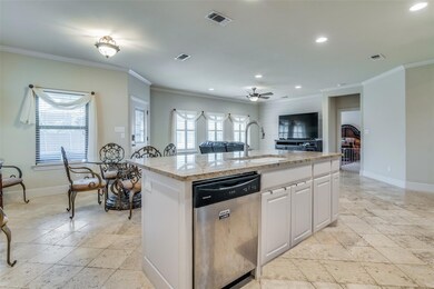 Specious bright kitchen features granite countertops, large island, plentiful cabinets, and lots of counter space
