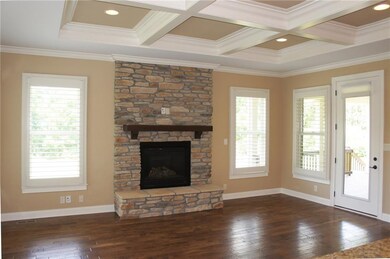 Hearth room off the kitchen with stone fireplace and door out to covered porch.