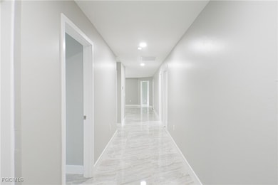 Hall with baseboards and recessed lighting