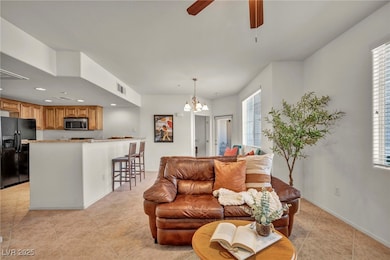 Living room featuring ceiling fan, a chandelier, l