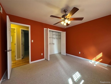 Unfurnished bedroom with carpet, a closet, and ceiling fan
