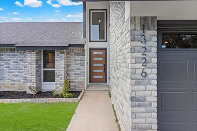 Entrance to property featuring brick siding and a shingled roof
