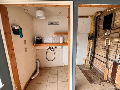 Clothes washing area with light tile patterned floors