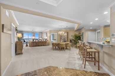 Dining room with ornamental molding, light colored carpet, baseboards, a chandelier, and recessed lighting