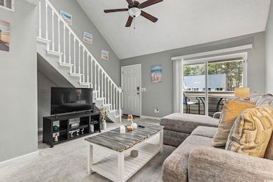 Carpeted living room featuring ceiling fan and hig