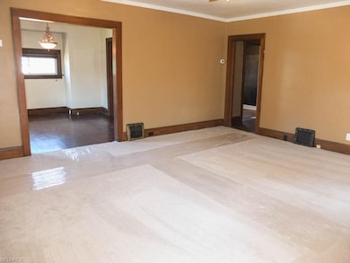 The living room has wide baseboards and crown mold