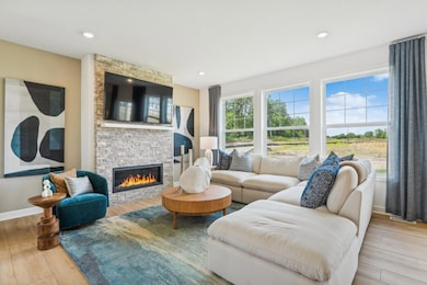 (Photo of model home, finishes will vary) A wall of large windows in the Great Room offer a sunlit view of the neighborhood and brighten daytime gatherings. It’s an ideal space for relaxing and enjoying the company of loved ones.