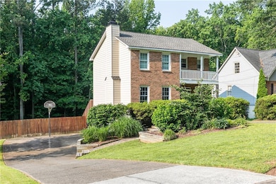 View of side/front of home with driveway able to park 4 ++ plus vehicles. Six foot wooden fence has large gate access to backyard.