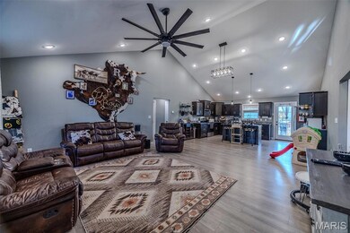 Living area featuring high vaulted ceiling, ceiling fan, light wood finished floors, and recessed lighting