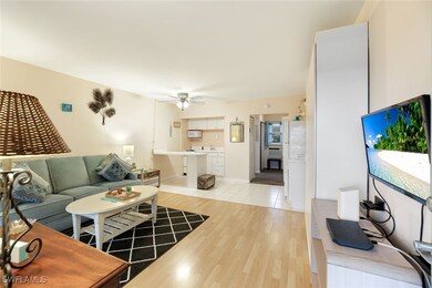 Living room with a ceiling fan and light wood-styl