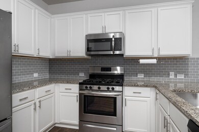 Kitchen with stainless steel appliances, white ca