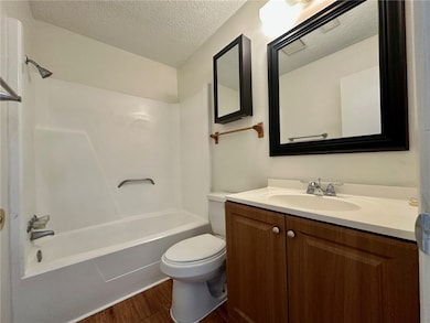 Bathroom with wood finished floors, vanity, bathin