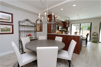 Dining area with ceiling fan with notable chandeli