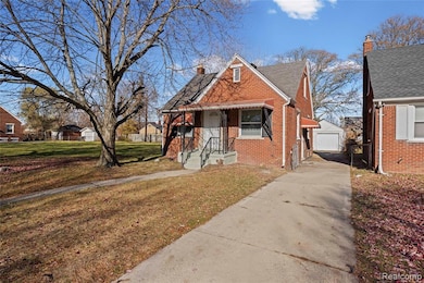 Bungalow featuring an outbuilding, a front lawn, a chimney, brick siding, and a shingled roof