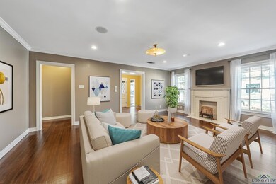 Living room featuring ornamental molding, wood finished floors, recessed lighting, and a fireplace