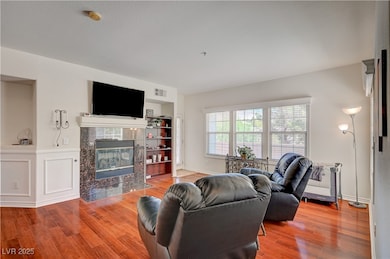 Living room featuring wood finished floors, a fire