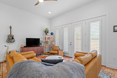 Living area featuring a ceiling fan, baseboards, 