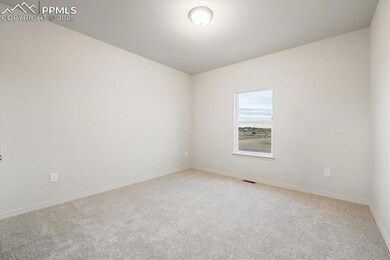 Unfurnished room featuring light carpet and baseboards