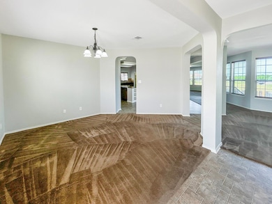 Carpeted spare room with arched walkways, a chand