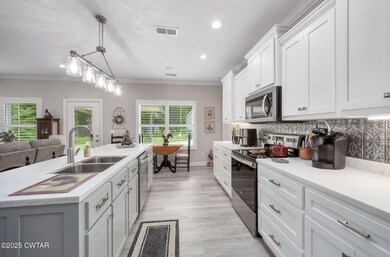 Kitchen with appliances with stainless steel finishes, healthy amount of natural light, light countertops, recessed lighting, and white cabinetry