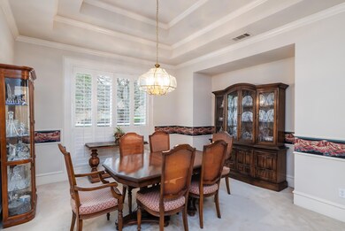 Formal dining room with trayed ceiling.