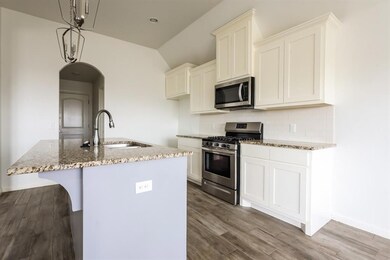 Kitchen with tasteful backsplash, white cabinets, 