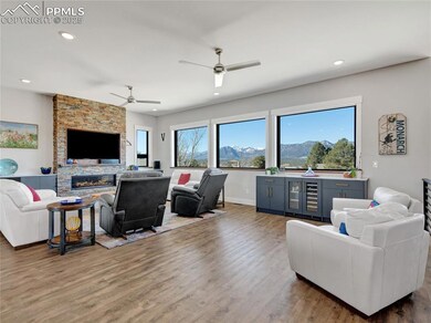 Living room with wine cooler, recessed lighting, a fireplace, wood finished floors, and a ceiling fan