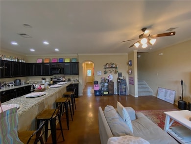 Kitchen with black microwave, stainless steel elec
