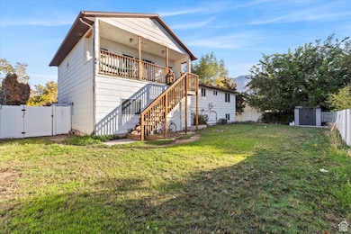 Back of house featuring a gate, stairs, and a storage shed