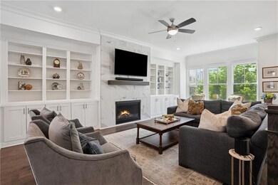 Living room with crown molding, ceiling fan, built