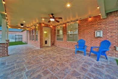 Spacious covered back patio complete with string lighting and ceiling fans