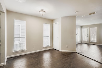 Unfurnished room featuring dark wood-type flooring and baseboards