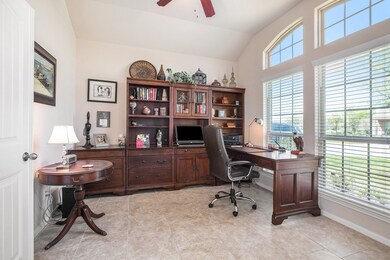 The home office has French doors, a ceiling fan and abundant lighting.
