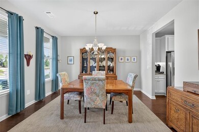 Dining room featuring dark wood-style floors and a chandelier
