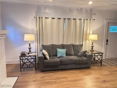 Living room featuring crown molding, wood-type flooring, and a fireplace