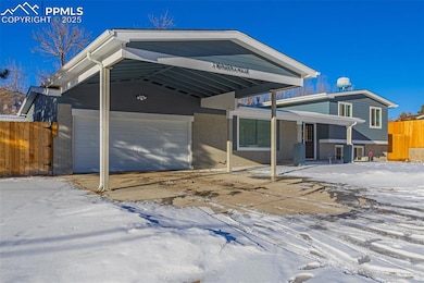 View of front facade with a garage and a carport