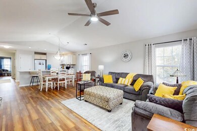 Living room featuring ceiling fan, vaulted ceiling