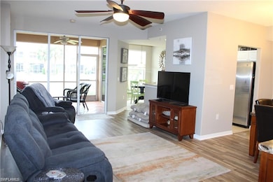 Living room with wood-type flooring and ceiling fan