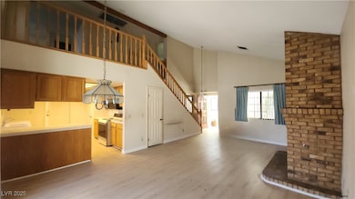 Unfurnished living room featuring stairs, light wo