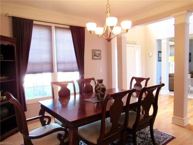 The dining room has hardwood floors and crown mold