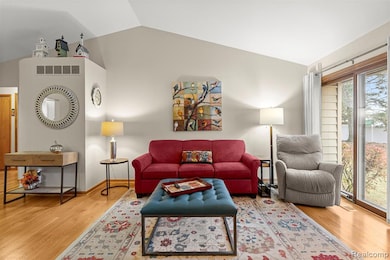 Living area featuring vaulted ceiling and light wood-style floors