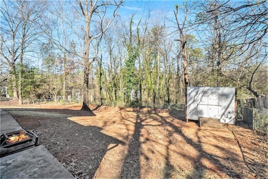 View of yard featuring a fire pit and a wooded view