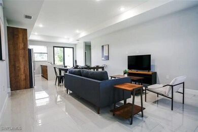 Living area with a tray ceiling, baseboards, visib