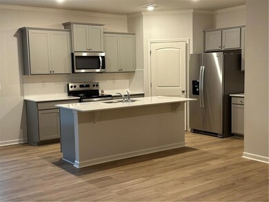 Kitchen featuring gray cabinets, tasteful backsplash, crown molding, stainless steel refrigerator, and range