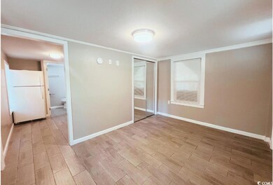 Unfurnished bedroom with freestanding refrigerator