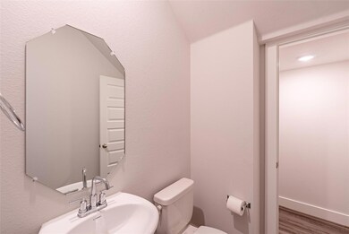 Half bath with toilet and wood finished floors